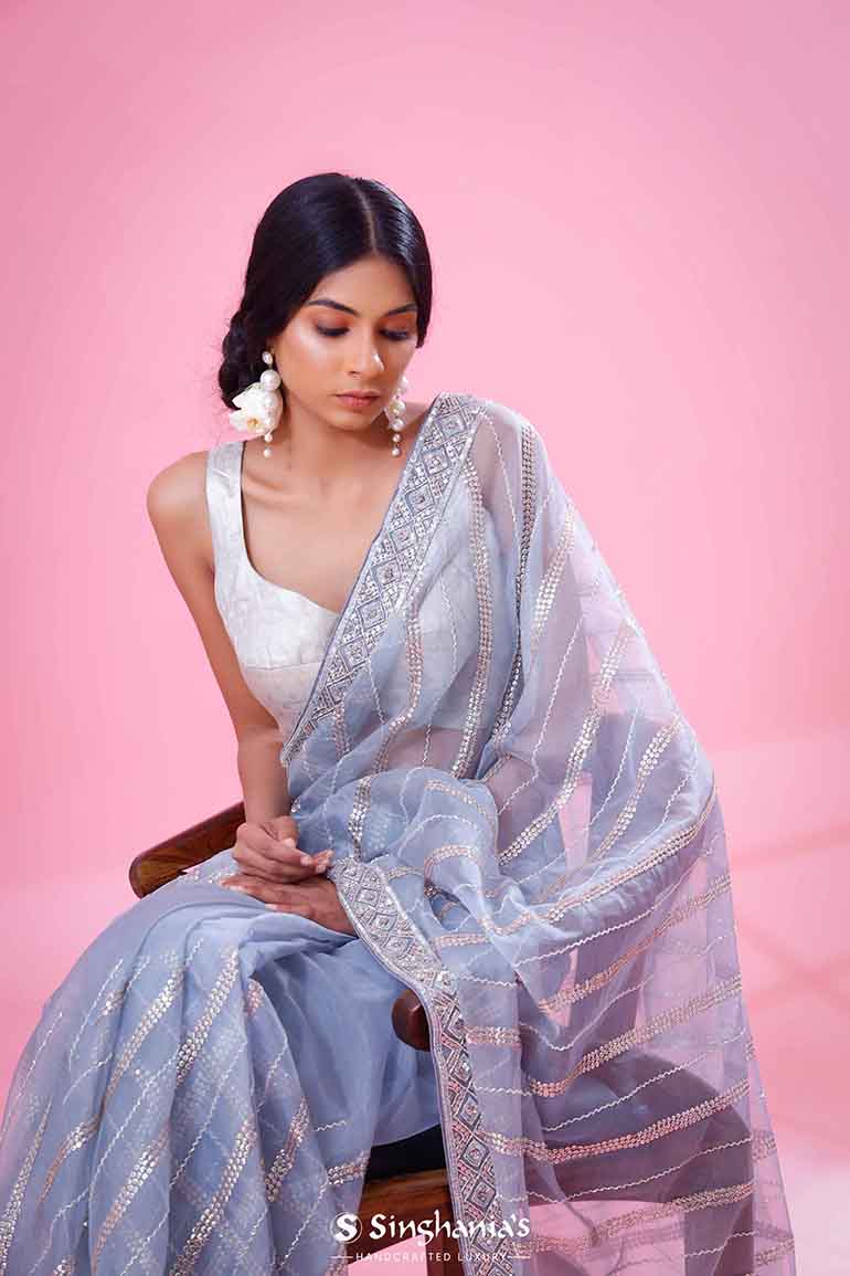 Pastel blue organza saree features sequins & thread embroidered zig-zag  geometric patterns, micro stone work border